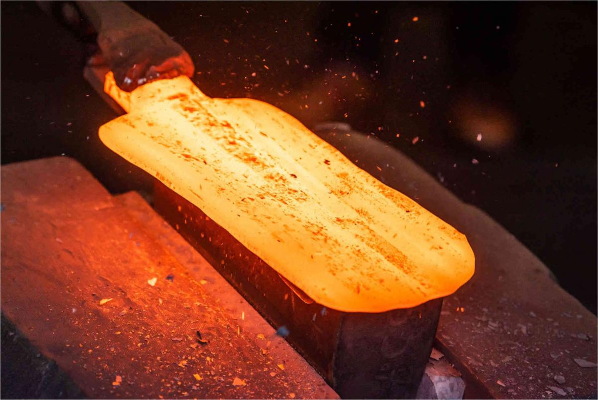 glühender Stahlrohling wird in der Manufaktur zu einem Spaten geschmiedet